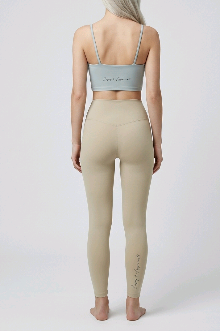 Person wearing a beige sports bra and leggings set on a white background