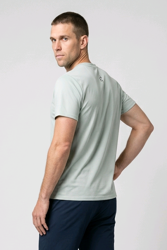 Man wearing a light green t-shirt and navy pants on a white background