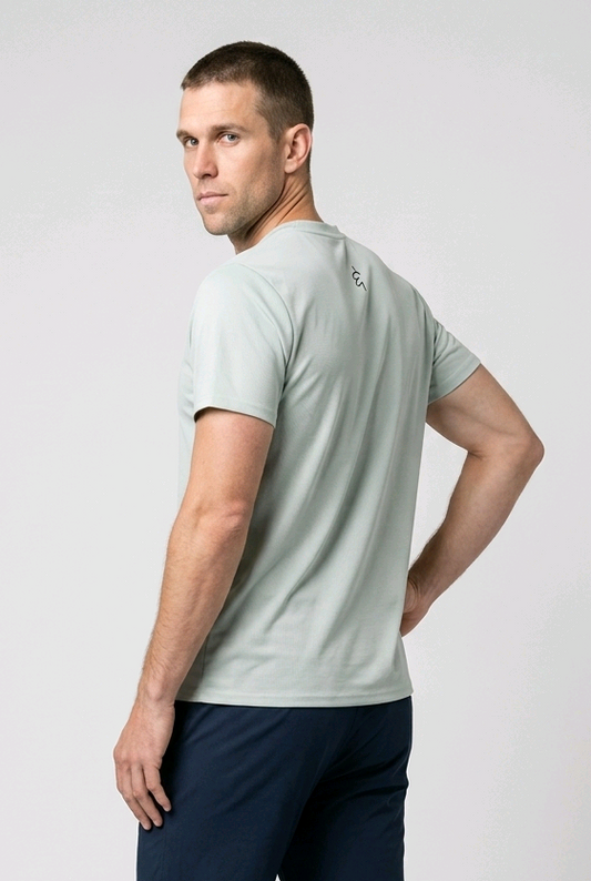 Man wearing a light green t-shirt and navy pants on a white background