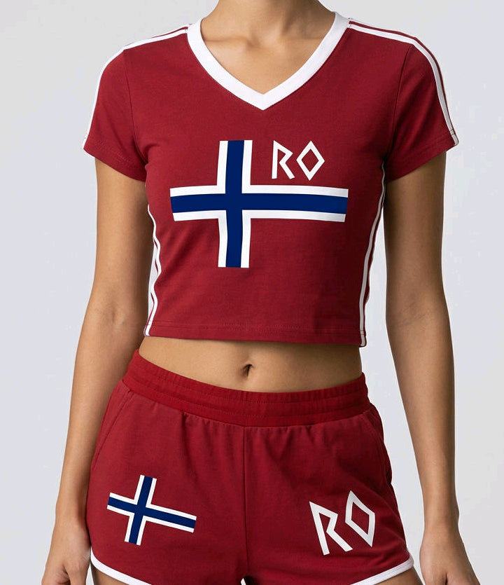 A model wearing a matching maroon crop top and shorts set with white and blue accents, featuring the Norwegian flag and 'RO' text on the front, against a light gray studio background.