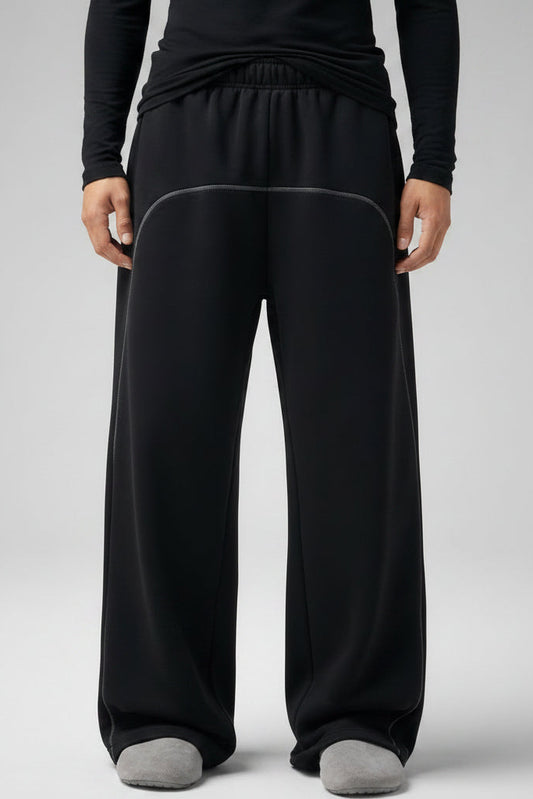 Person wearing black sweatpants on a gray background