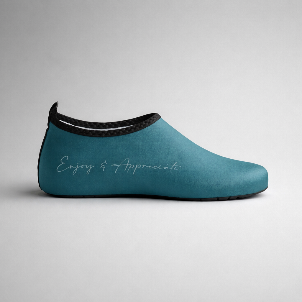 Teal slip-on aqua shoe with black trim and subtle enjoy and appreciate script embossed on the side for barefoot intention