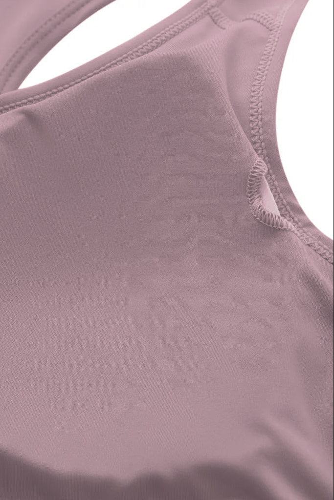 A soft mauve racerback sports bra made of smooth stretchy fabric with neatly stitched seams for activewear use