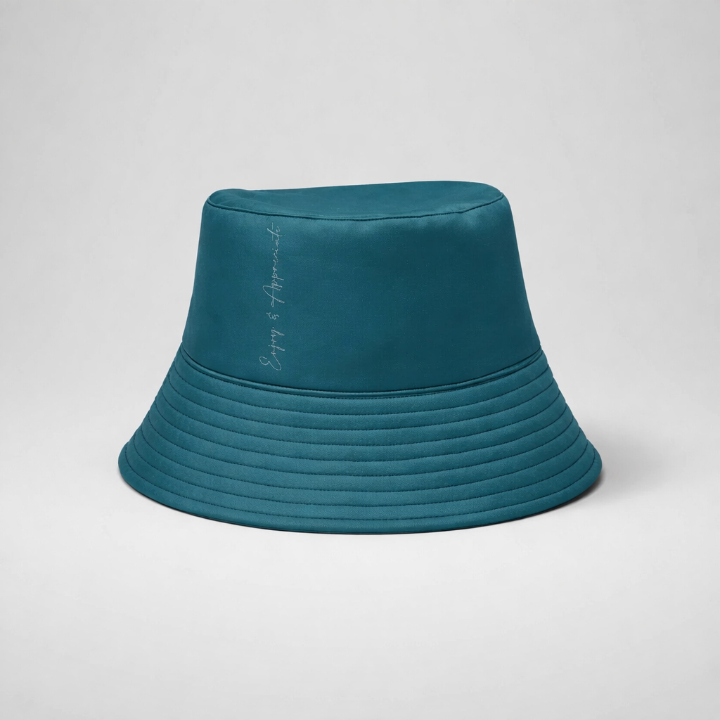 Teal quilted bucket hat with subtle embroidered phrase on the side made from soft fabric for casual wear
