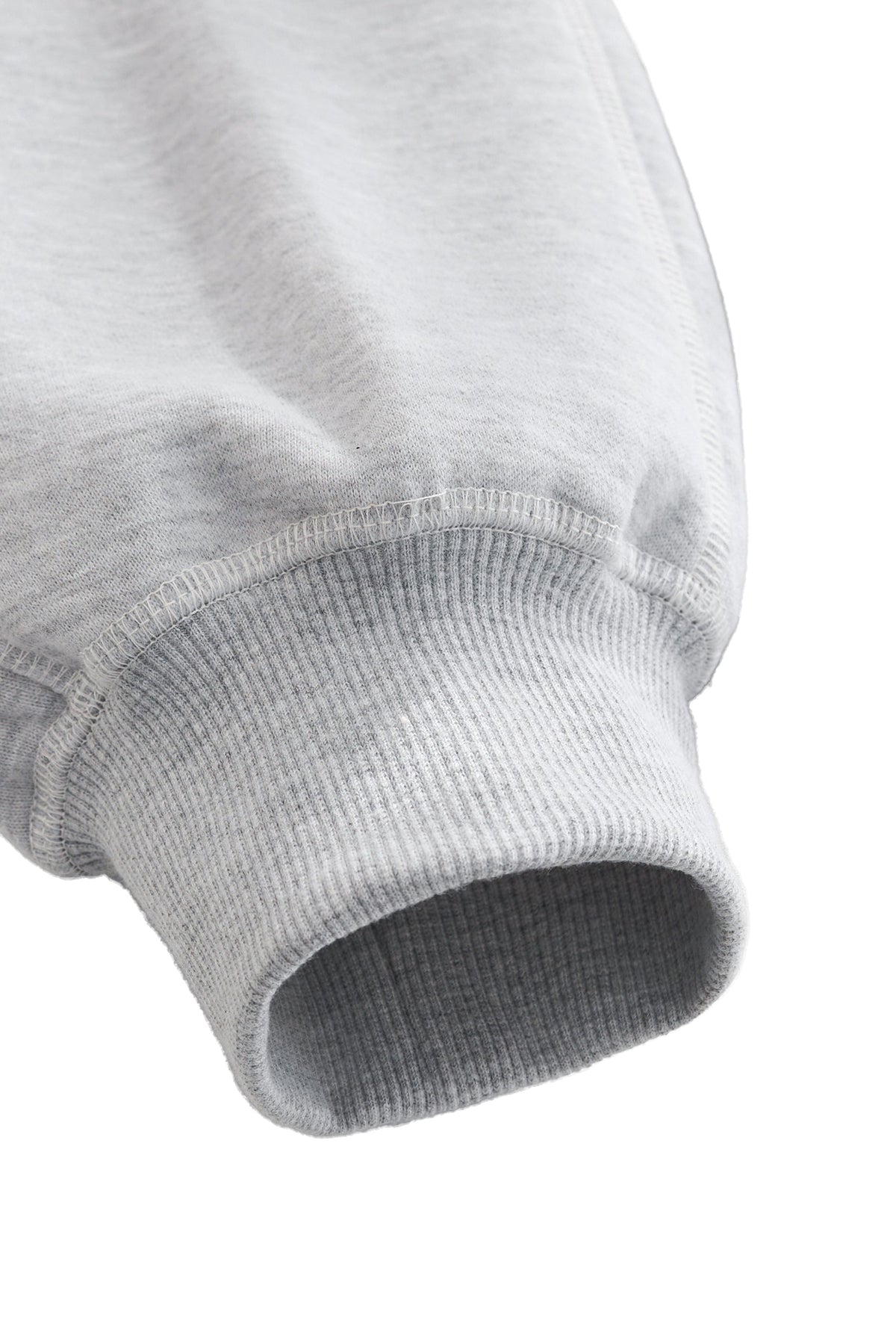 Close-up of a gray ribbed sweater sleeve on a white background