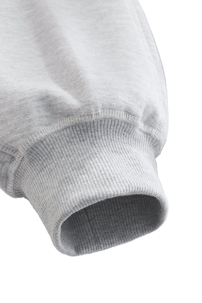 Close-up of a gray ribbed sweater sleeve on a white background