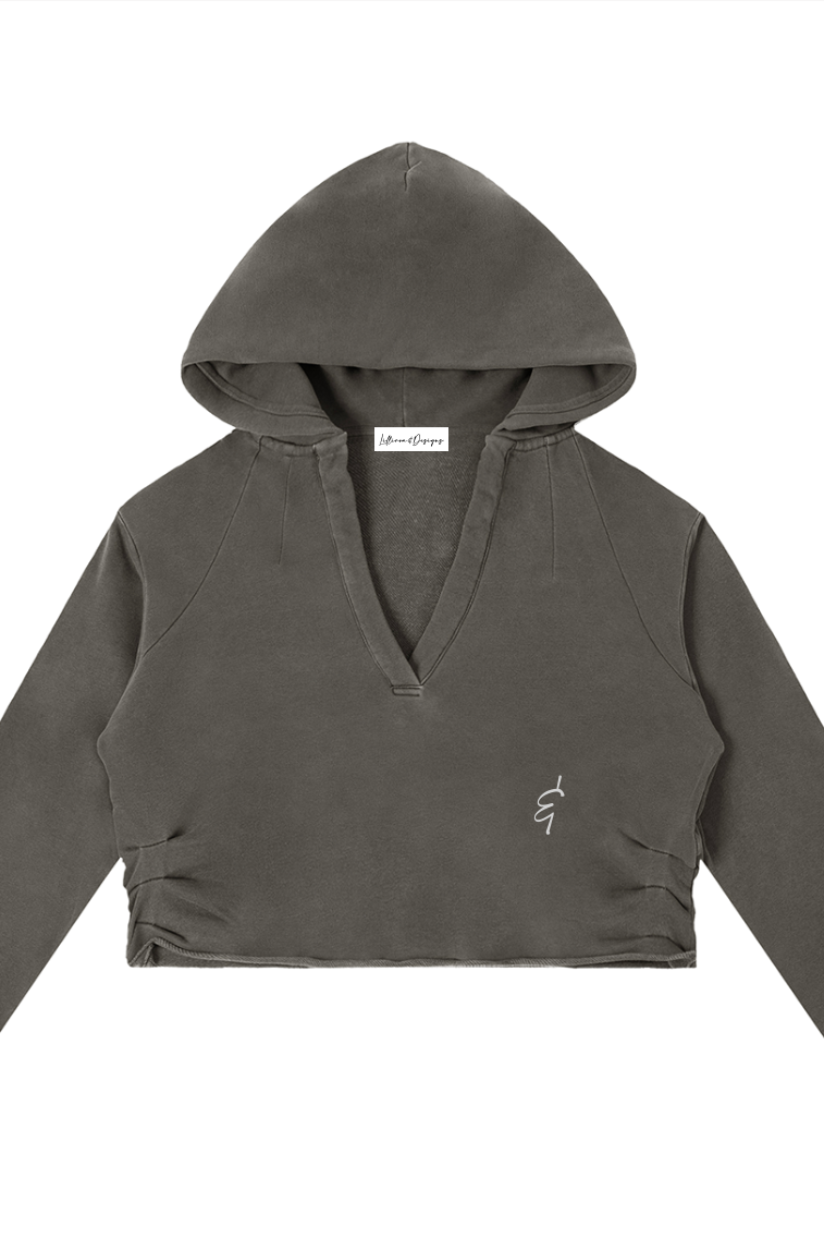 A dark olive green cropped raw edge hoodie with v-neckline long sleeves and embroidered logo on the left chest