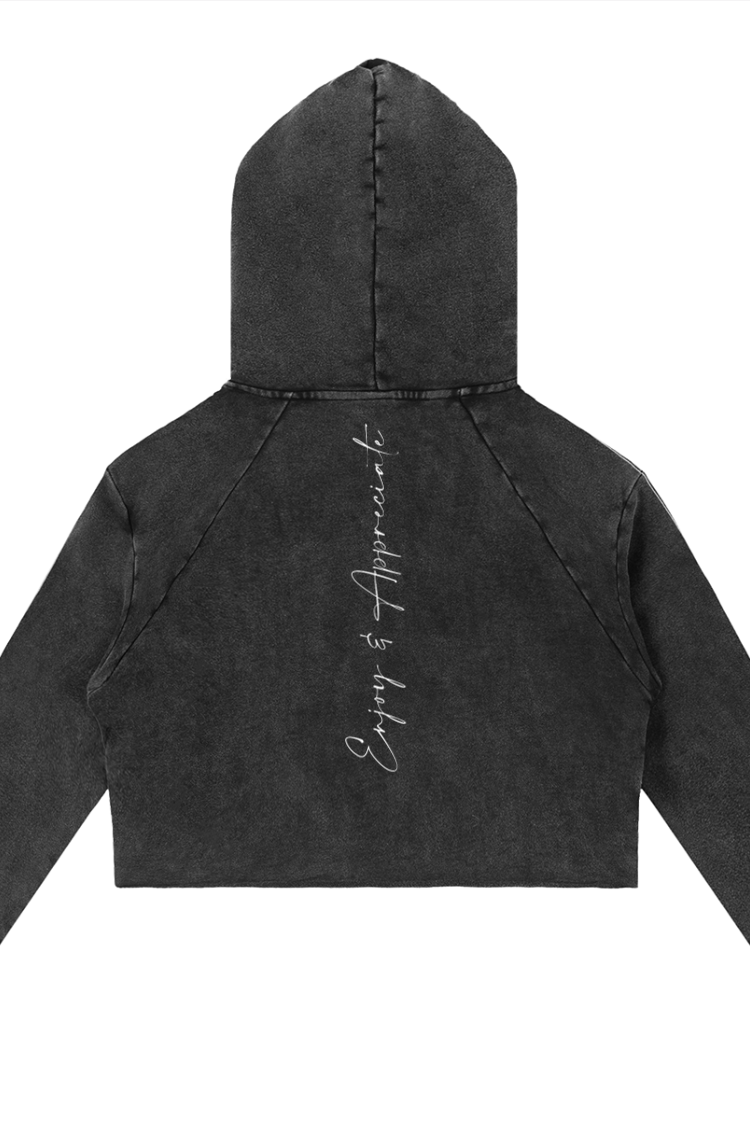 Back side of black cropped raw edge hoodie with faded texture and enjoy is appreciate embroidered in white cursive