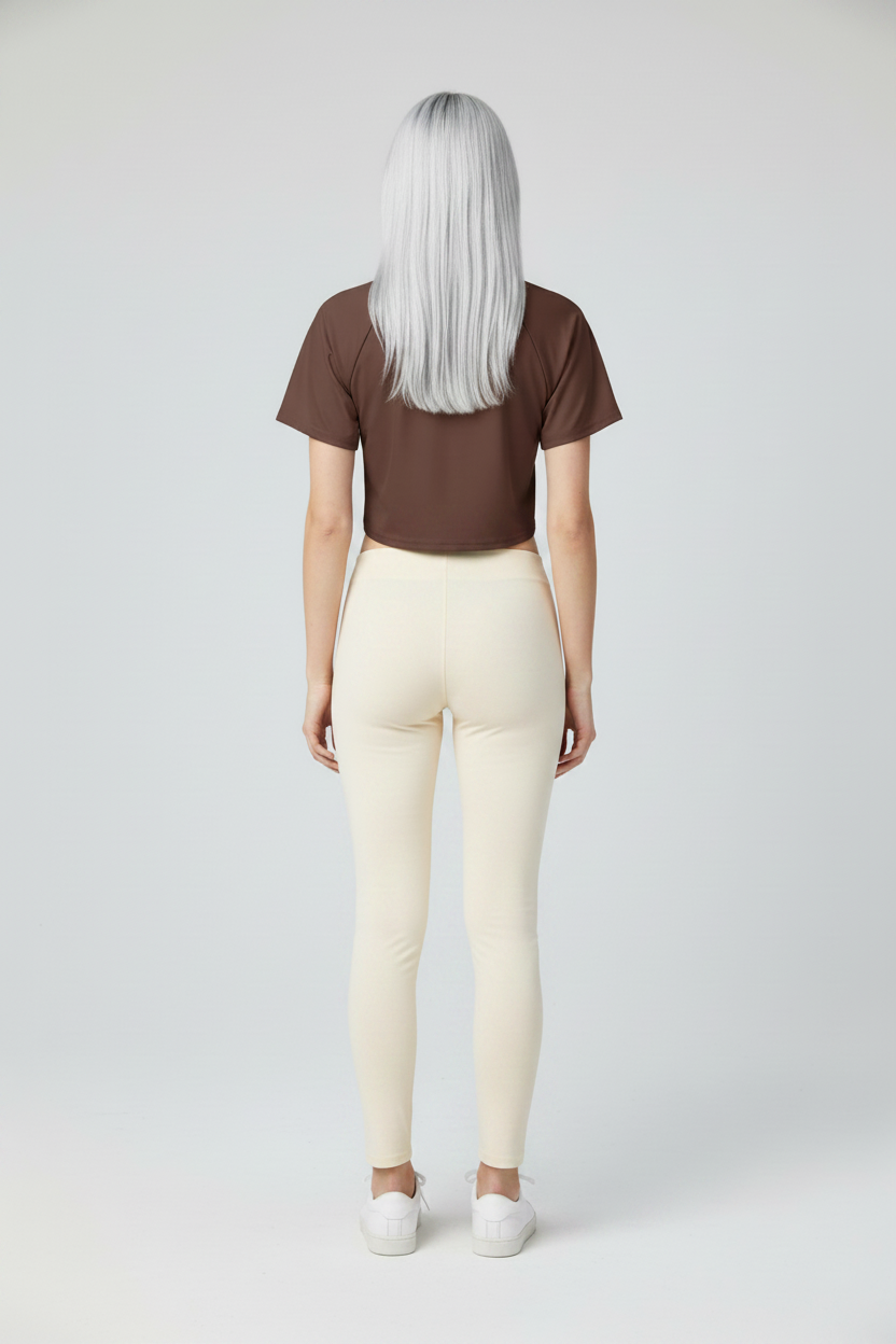 Person wearing a brown t-shirt and cream leggings on a white background