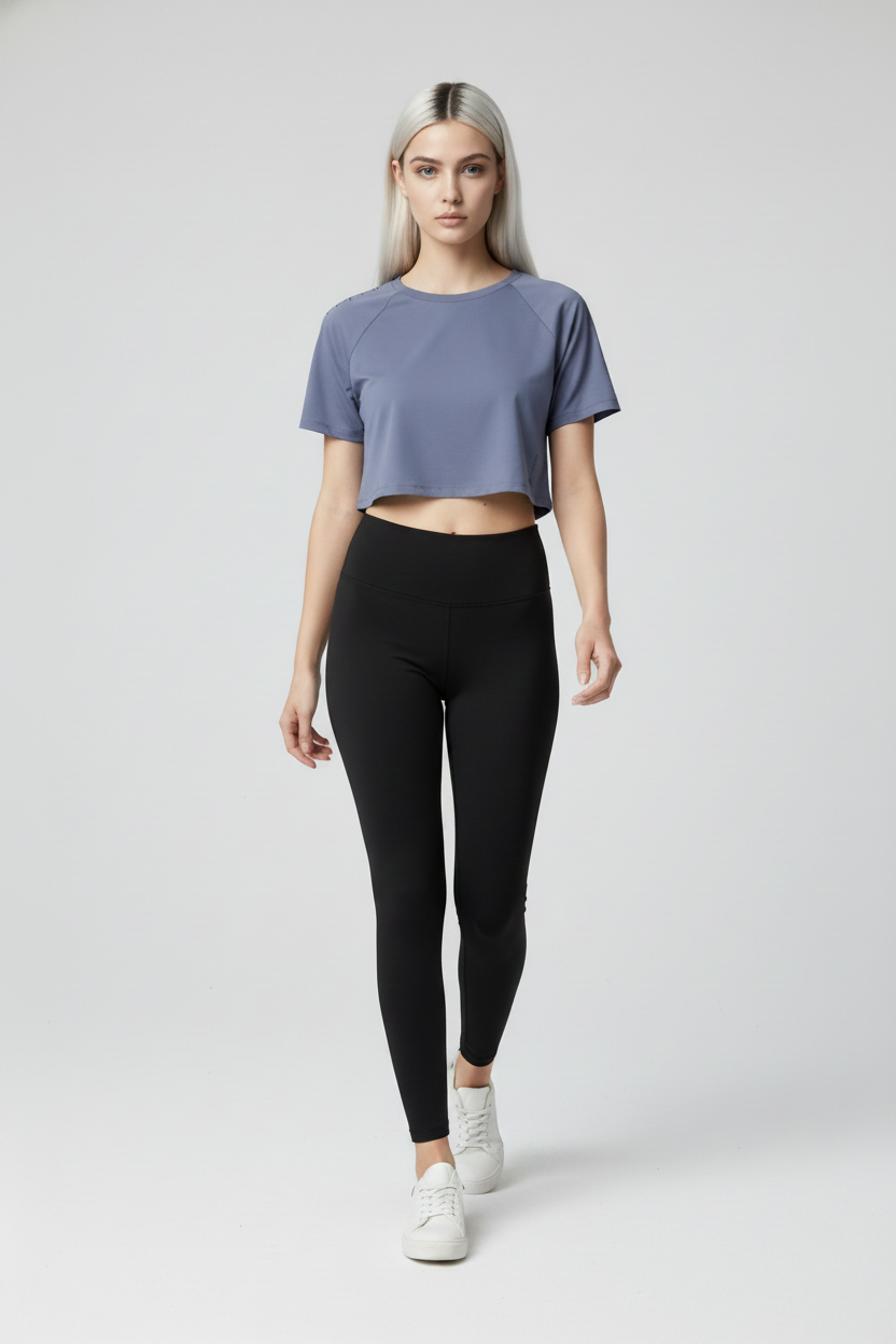 Woman wearing a blue crop top and black leggings on a white background