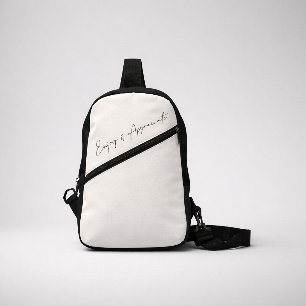 White and black crossbody bag with enjoy and appreciate script in silver on the front for casual use