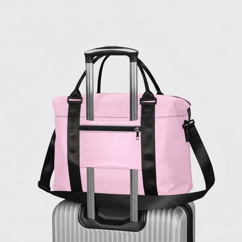 Pink travel duffel bag with black straps and silver telescoping handles for easy transport and durable use