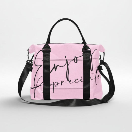Pink duffel bag with black handles and shoulder strap featuring enjoy appreciate in elegant cursive script