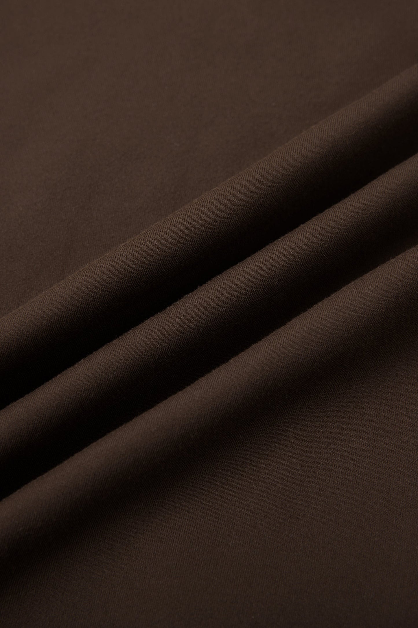 Close-up of dark brown fabric with folds