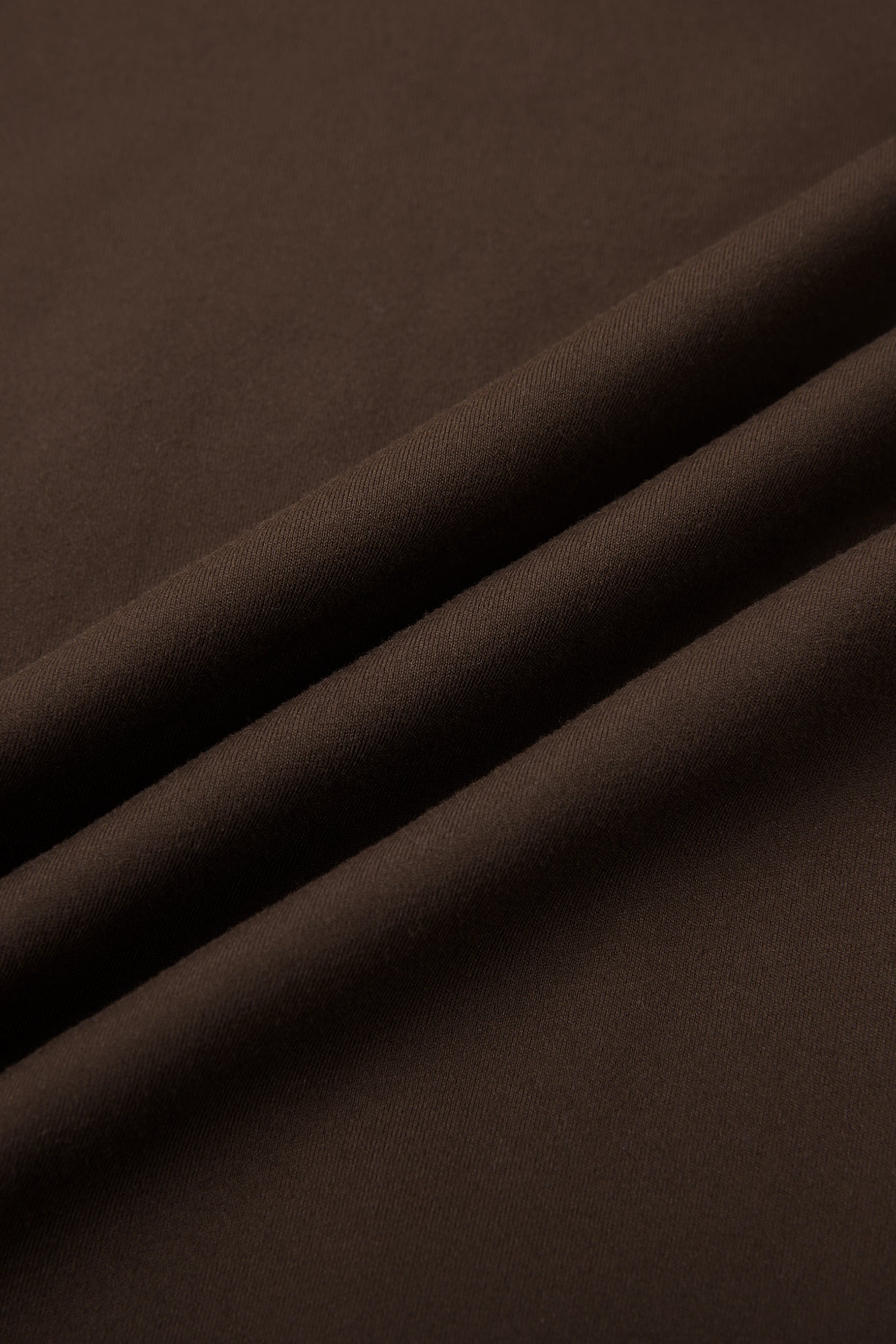 Close-up of dark brown fabric with folds