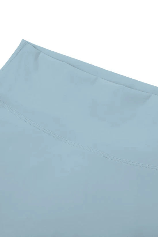 Light blue satin high-waisted seamless flared leggings with subtle stitching along the edge