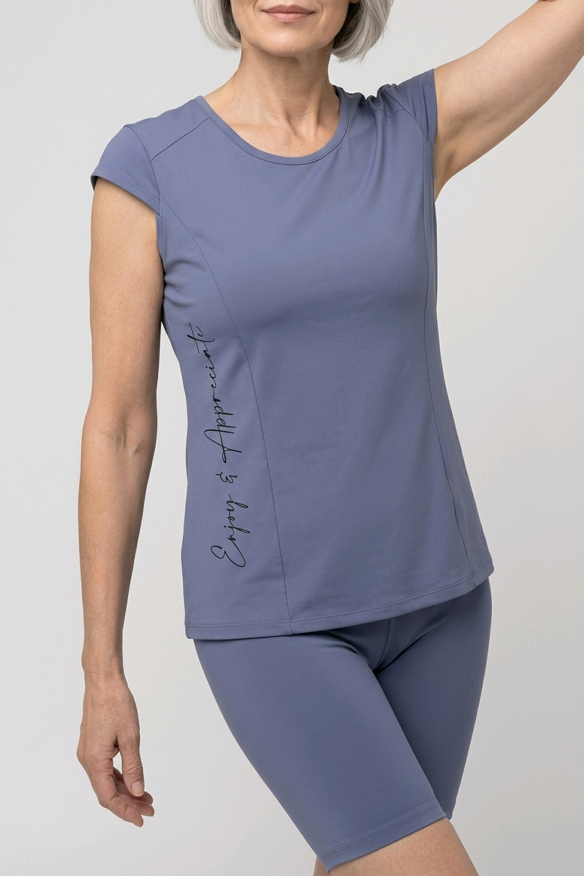 Woman wearing a purple athletic outfit with text enjoy & apprecaite on a plain background