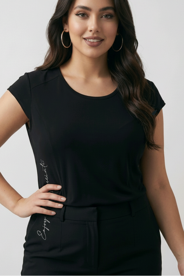 Woman wearing a black dress with a subtle design on a plain background