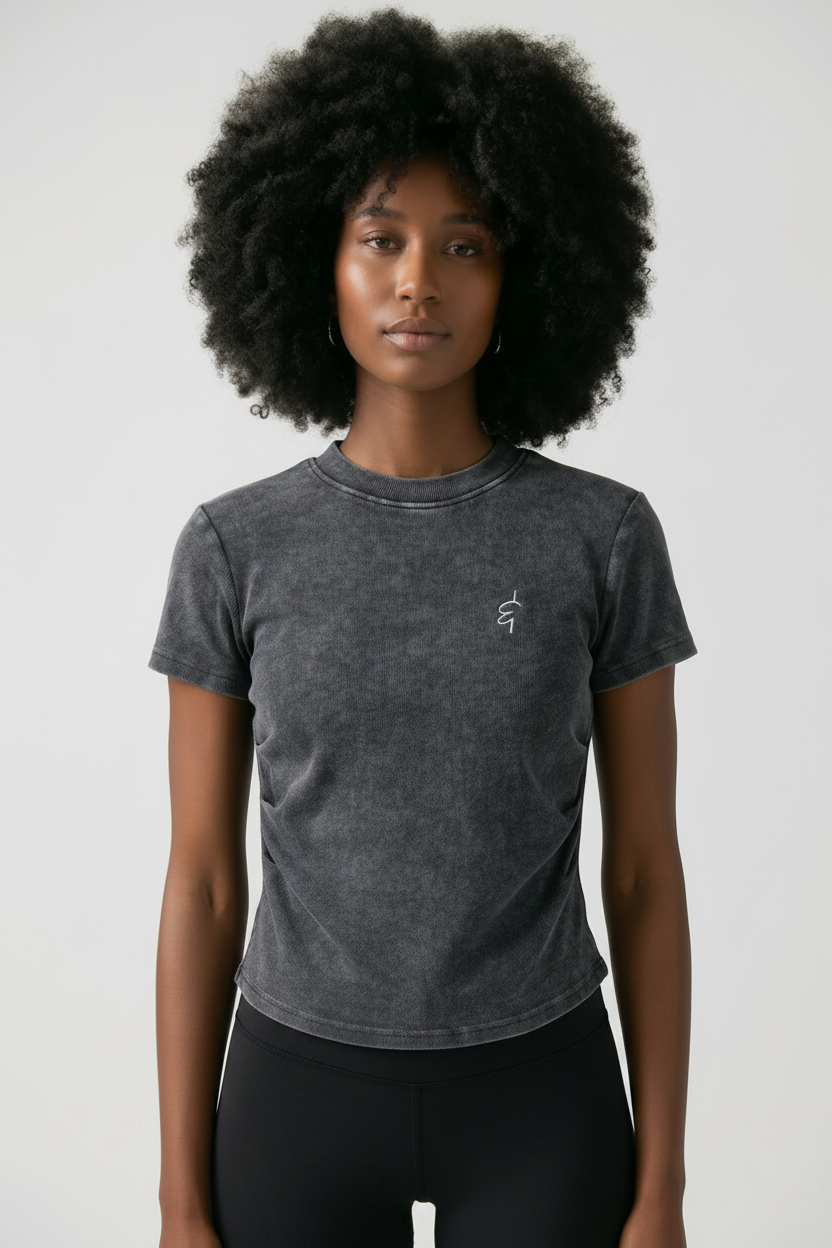 Person wearing a dark gray t-shirt with a small ampersand logo on a plain background
