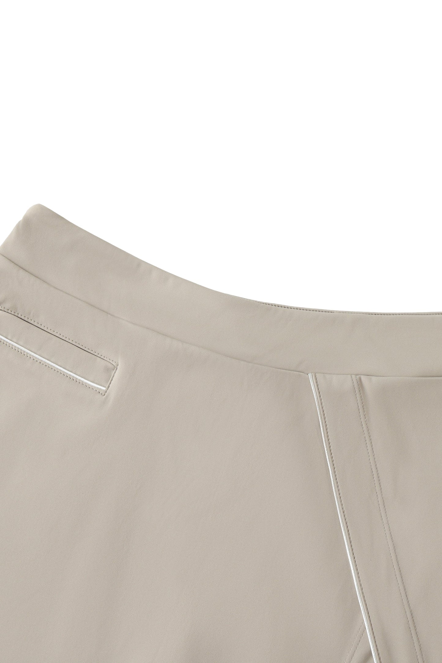 Close-up of beige skirt waist with white piping on a white background