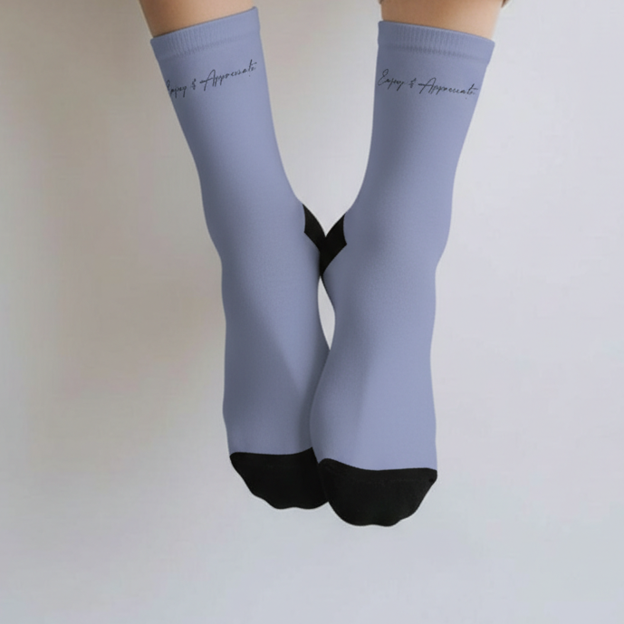 Light blue ankle-high socks with black toes and cuffs on a plain background