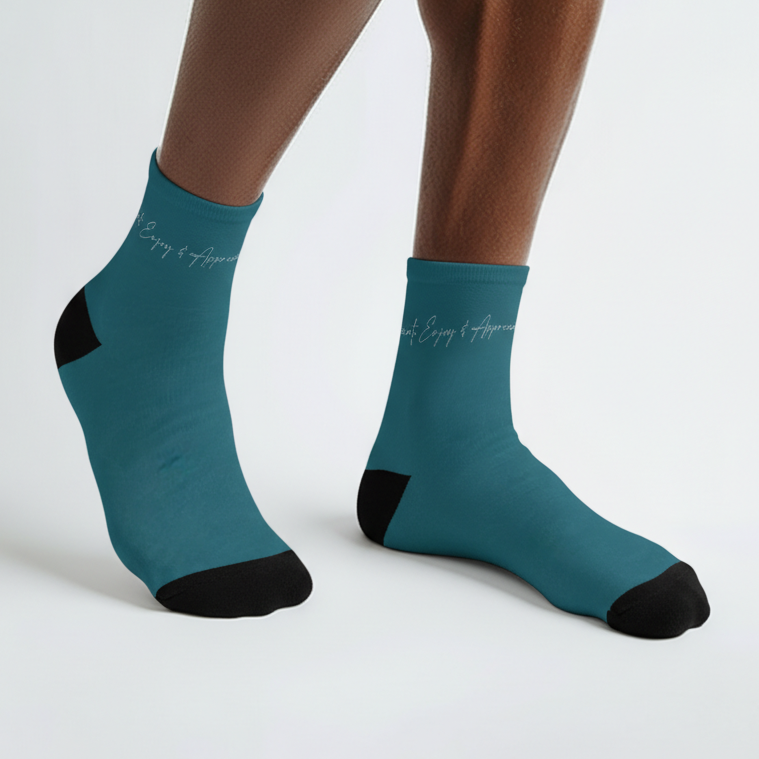 Teal ankle socks with black toe and heel accents and subtle white cursive script along the cuff