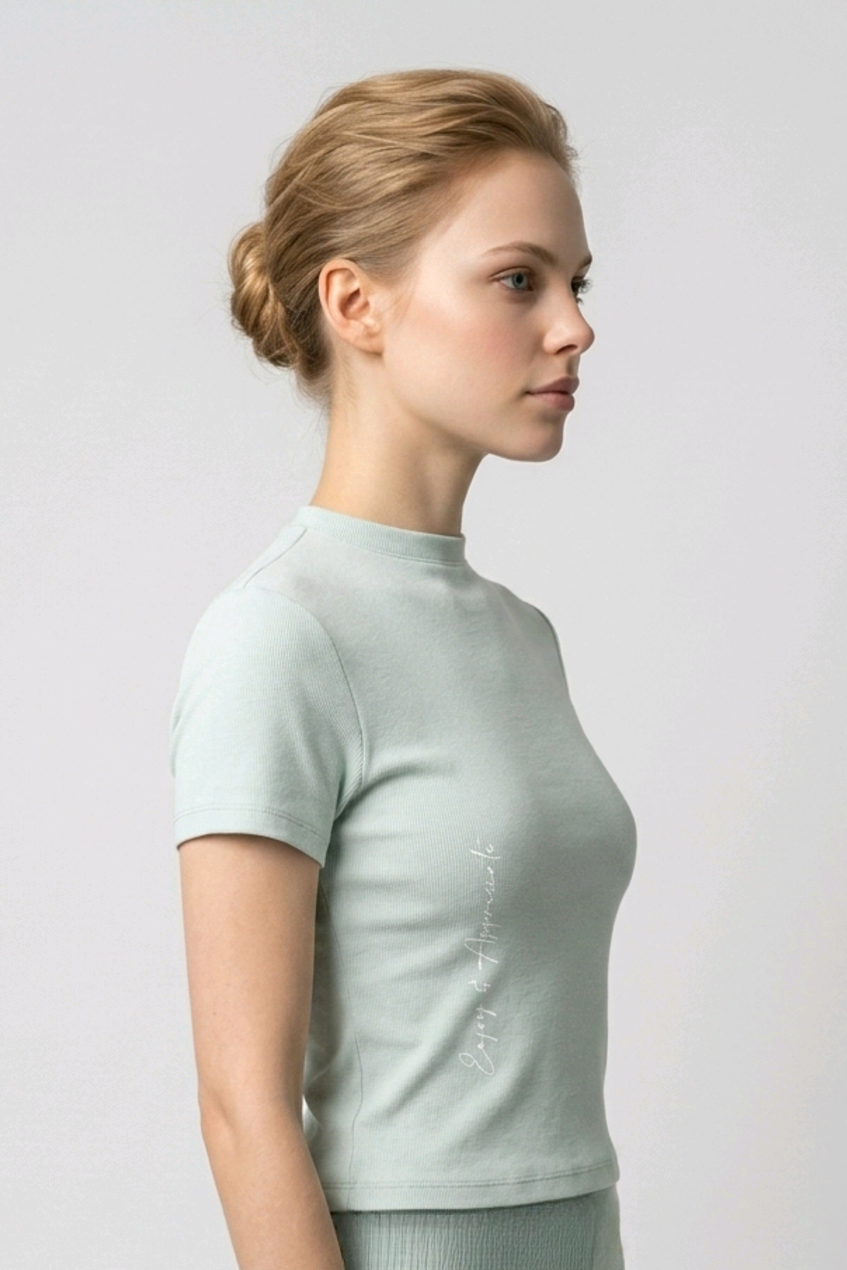 Woman wearing a light green ribbed mock neck t-shirt on a plain background