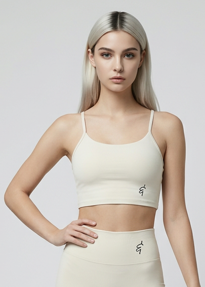 Cream-colored seamless sports bra with thin spaghetti straps and subtle embroidered logo on the front
