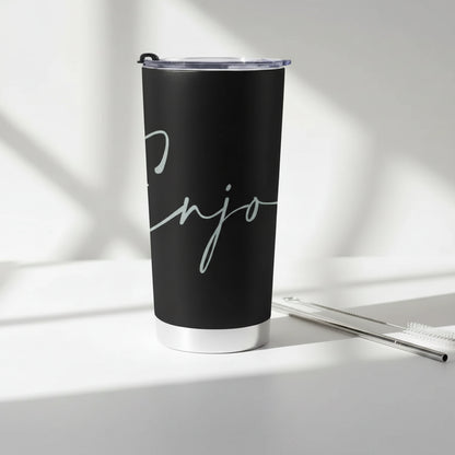 Black tumbler with 'Enjoy' text with a cleaning brush and metal straw on a light background