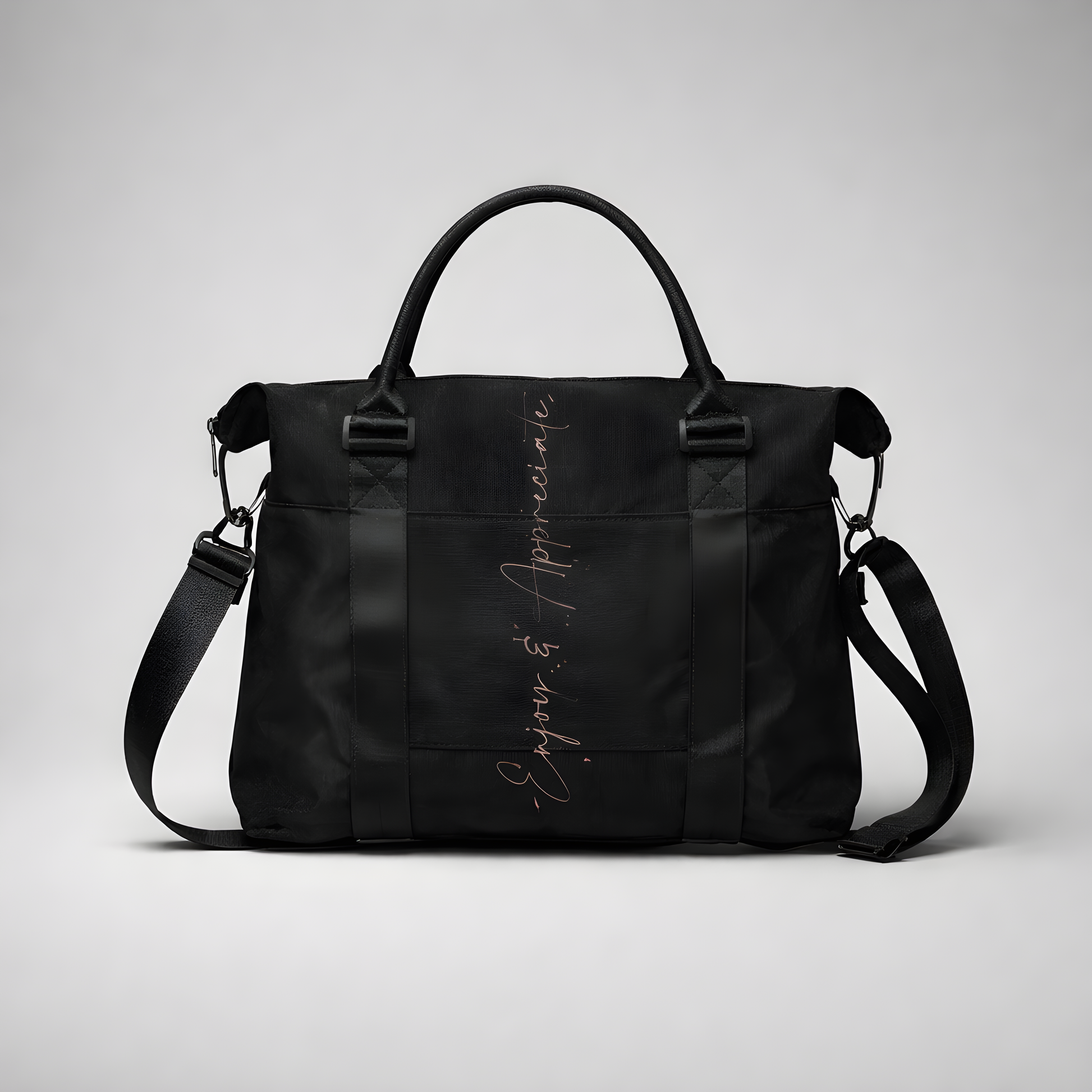 Black nylon travel bag with intention duffel featuring adjustable shoulder strap top handles and silver enjoy & appreciate script