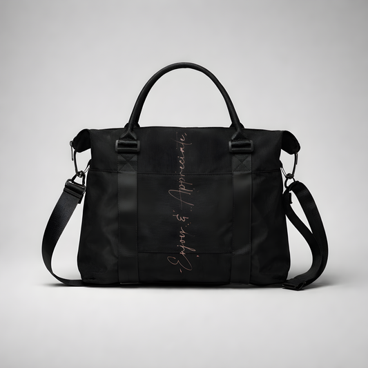Black nylon travel bag with intention duffel featuring adjustable shoulder strap top handles and silver enjoy & appreciate script