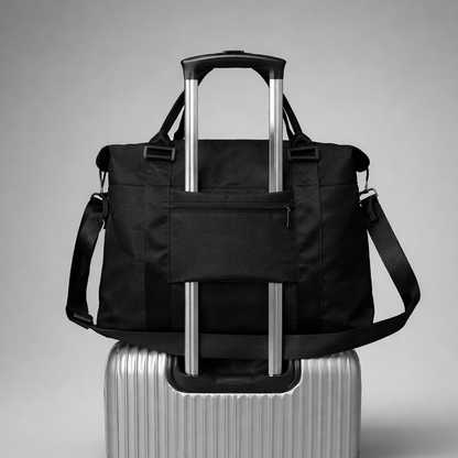 Black nylon rolling duffel bag with silver telescoping handle and adjustable shoulder strap for intentional travel