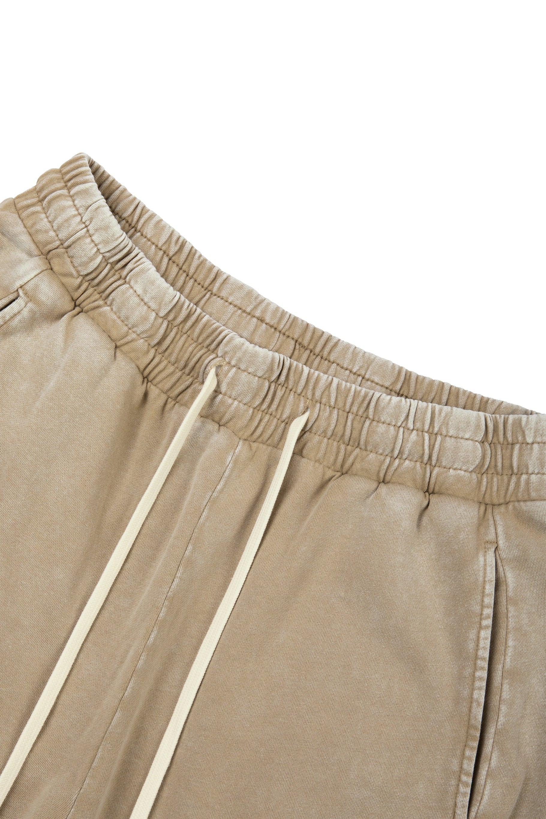 Close-up of beige pants with drawstring on a white background