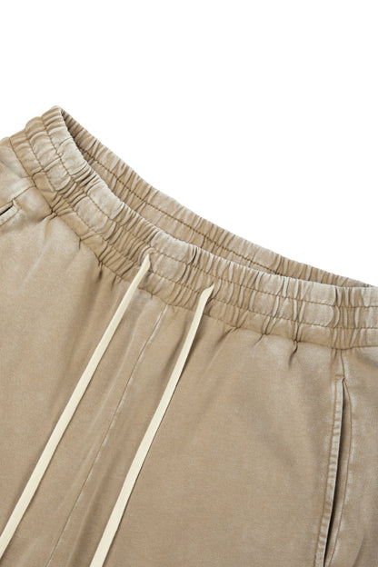 Close-up of beige pants with drawstring on a white background