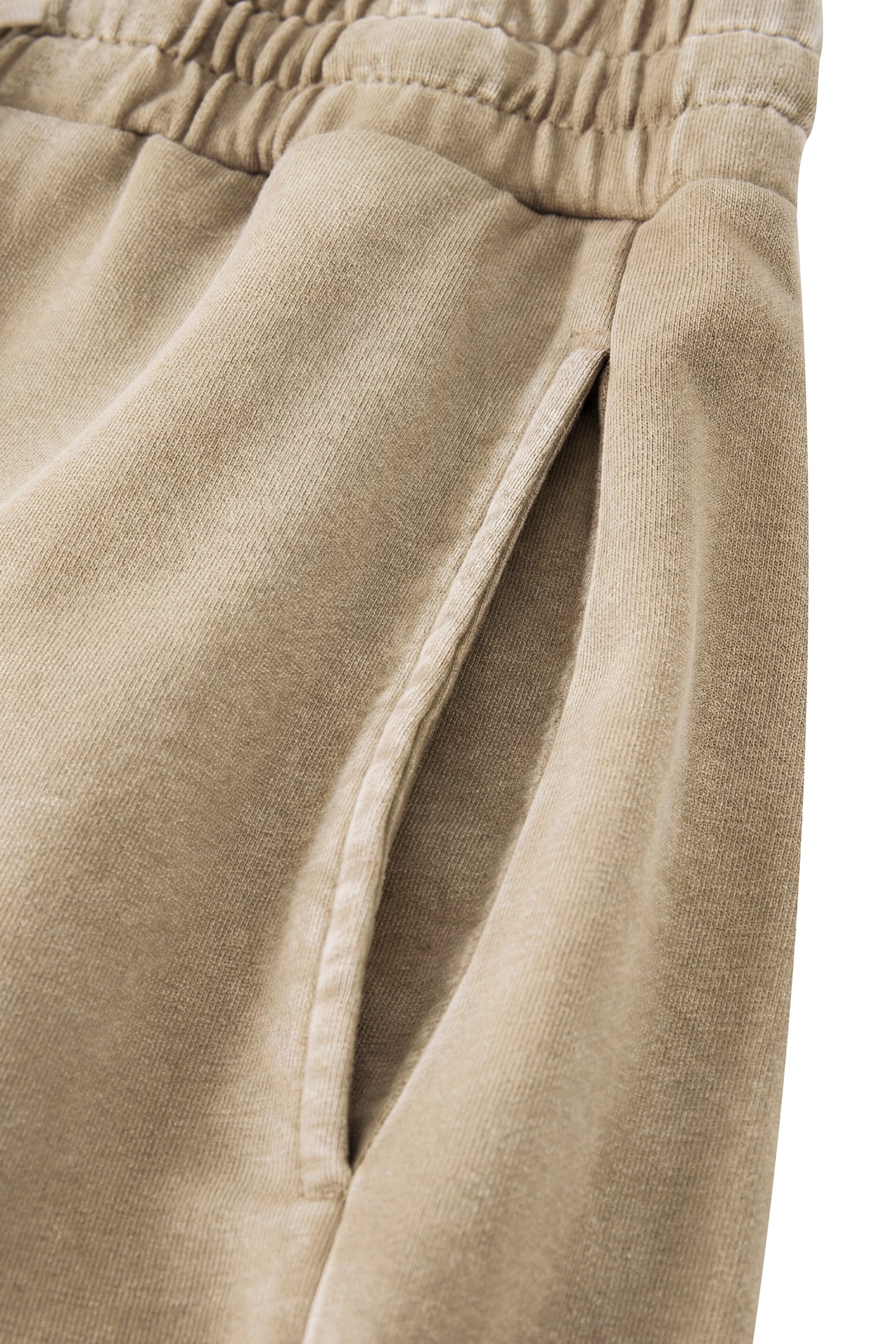 Close-up of beige pants with an elastic waistband on a white background