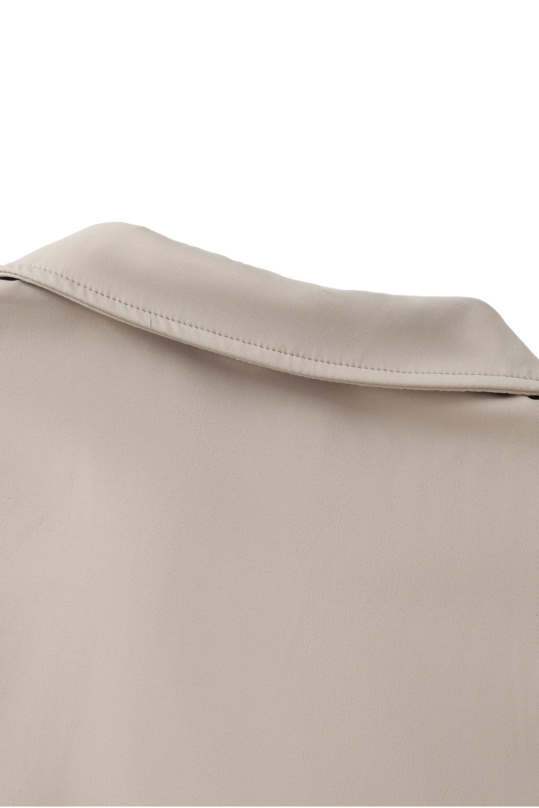 Close-up of a beige fabric texture with a collar