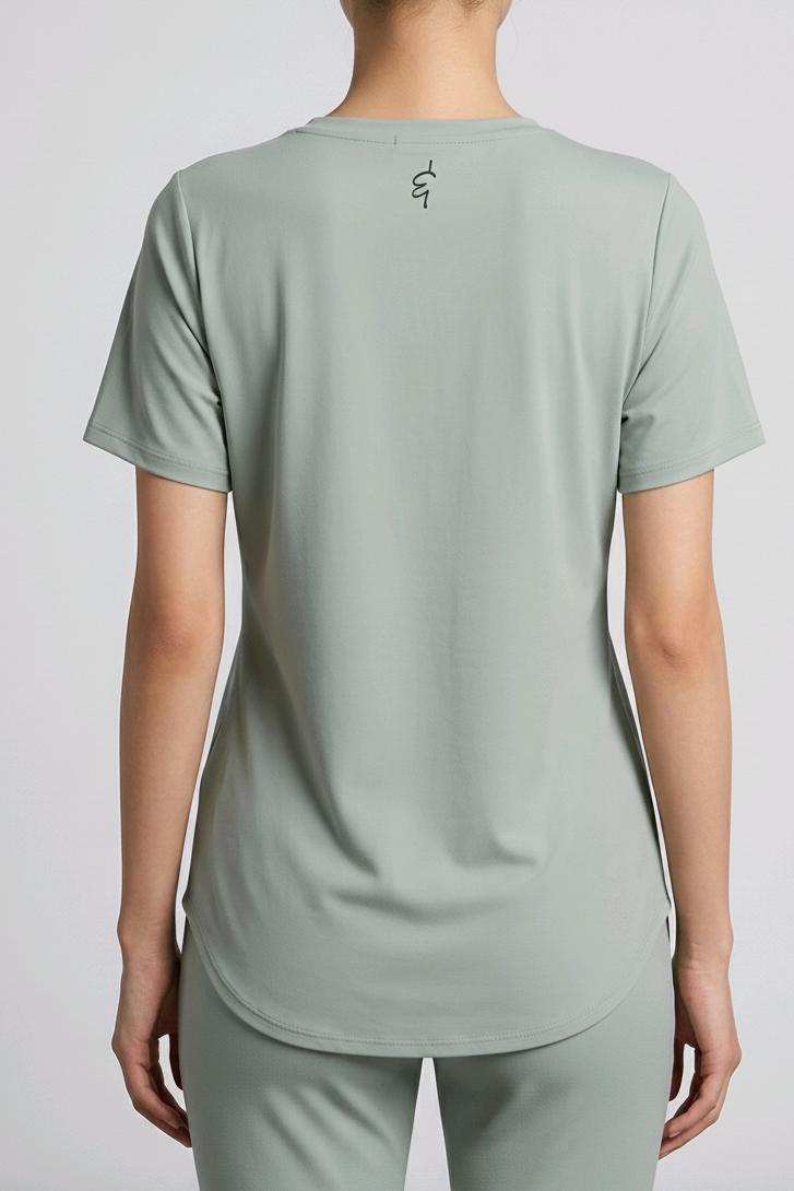 Person wearing a a green gray t-shirt and pants set on a light gray background