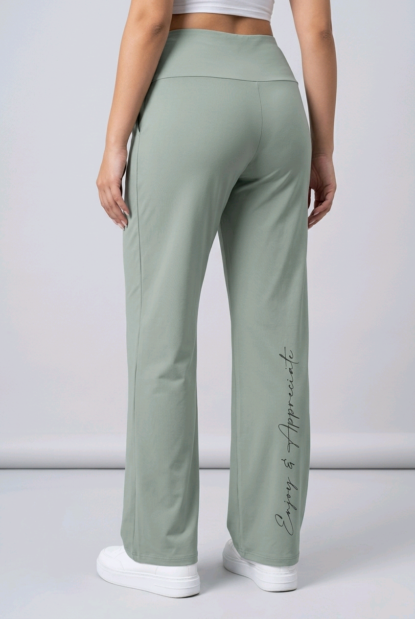 Green pants worn by a woman standing against a plain background