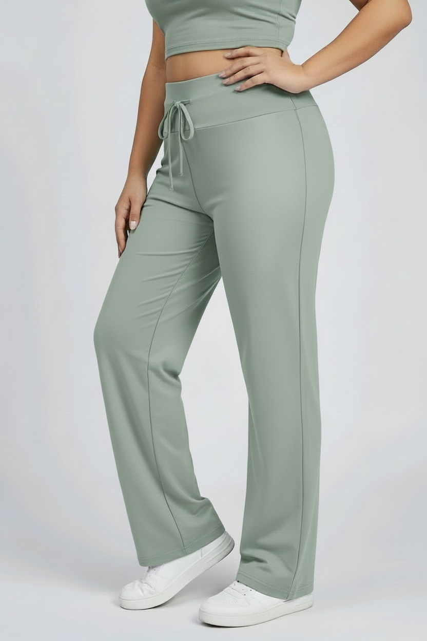 Person wearing light green drawstring waist jogger pants and a cropped top on a plain background