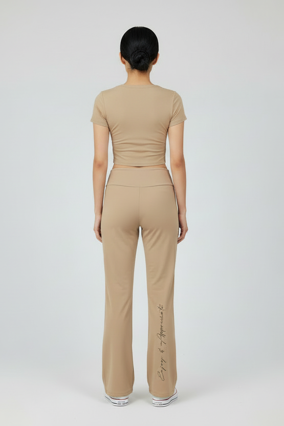 Person wearing a beige outfit with Enjoy & Appreciate branding on a white background