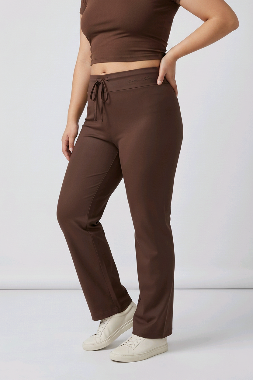 Woman wearing a brown top with drawstring waist pants on a white background