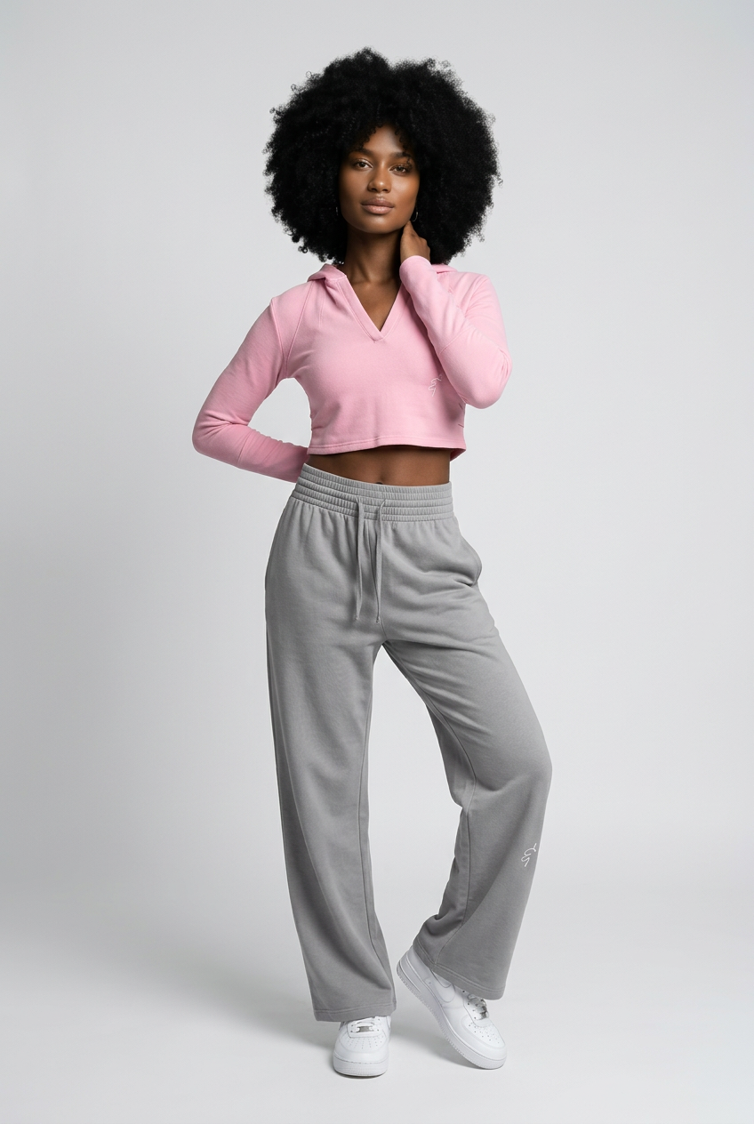 A soft pink cropped hoodie with long sleeves and v-neckline styled with wide leg sweatpants for casual wear