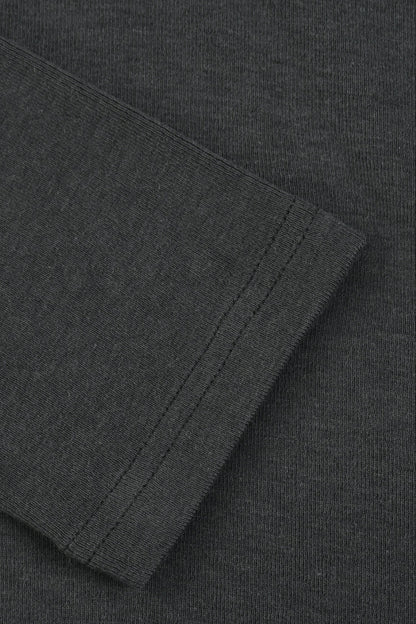 Close-up of a dark charcoal gray ribbed knit fabric, showing a folded cuff or sleeve edge with fine stitching.