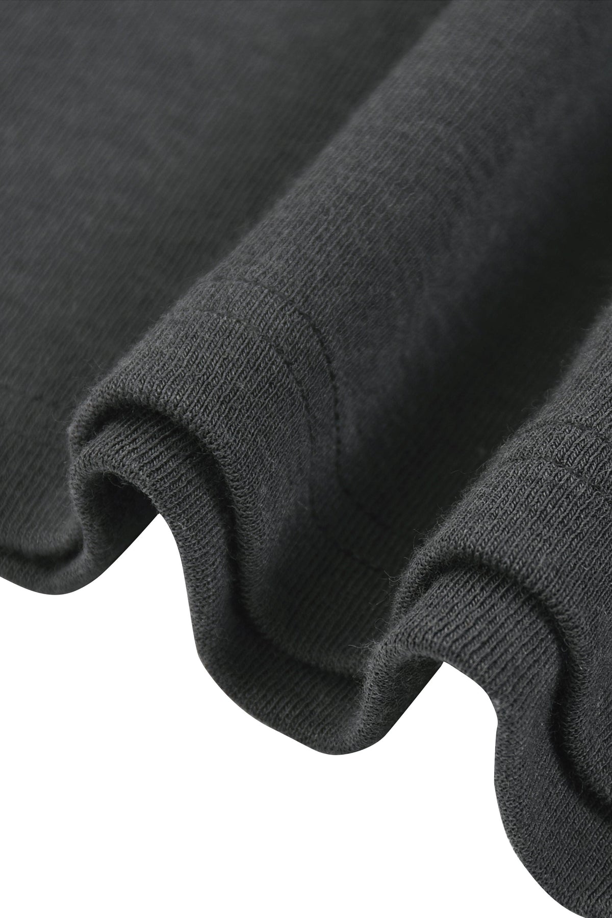 Close-up of a dark charcoal gray ribbed knit fabric, showing the texture and folded edges against a white background.