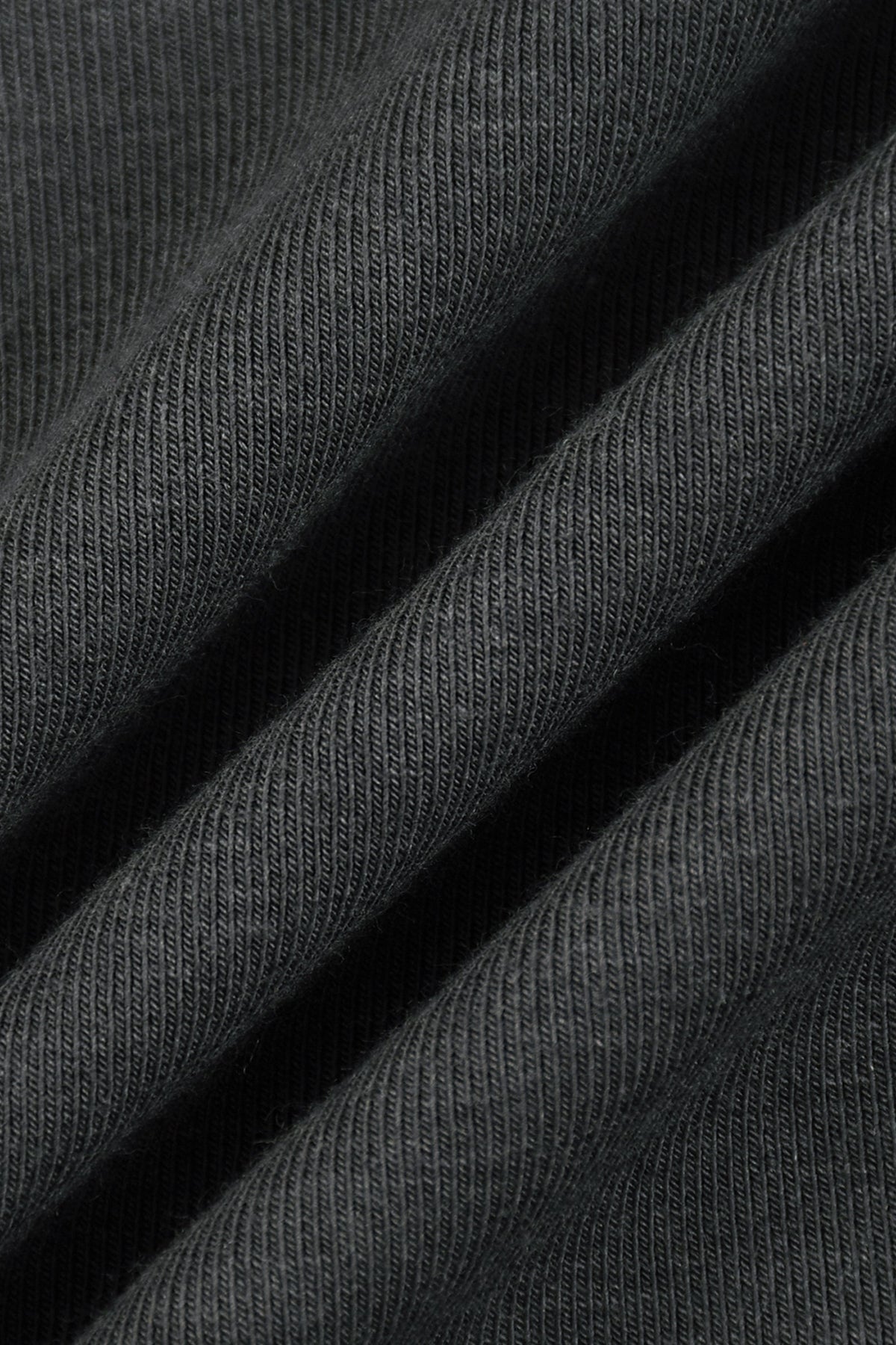 Close-up of dark charcoal gray ribbed knit fabric with soft diagonal folds showing the texture and weave.