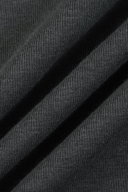 Close-up of dark charcoal gray ribbed knit fabric with soft diagonal folds showing the texture and weave.
