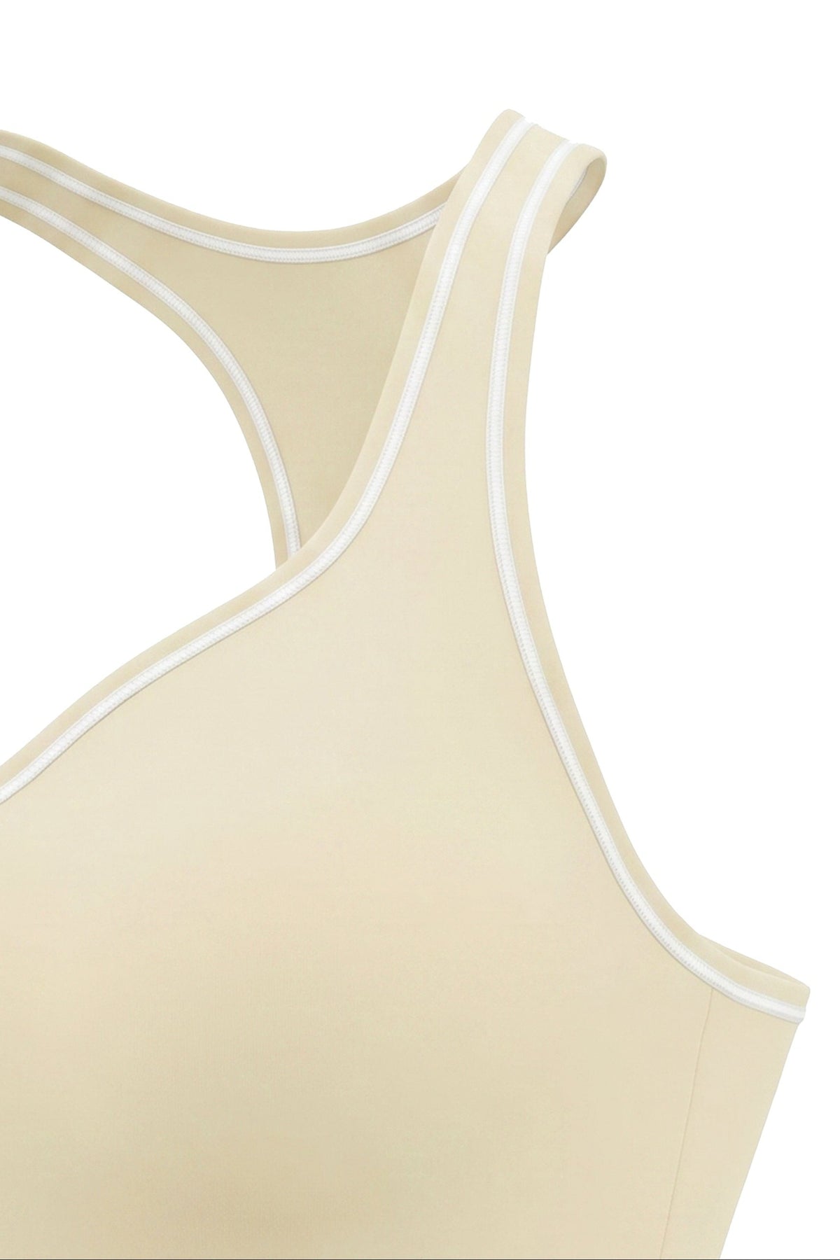Close-up of a beige sports bra or tank top with white contrast piping along the neckline and racerback straps, shown on a plain white background.