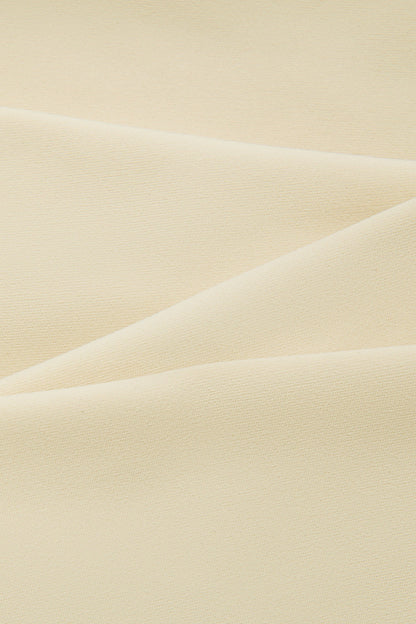 A close-up of draped cream-colored fabric with soft folds and a smooth texture.