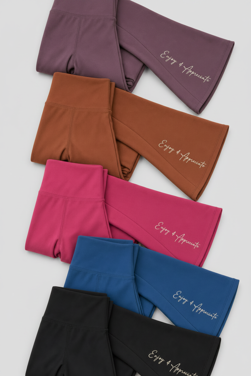 Six pairs of folded high-waisted leggings in purple, brown, pink, blue, and black, arranged diagonally on a light cream background. Each pair features the brand name 'Enjoy All Around' embroidered in white script on the outer leg.