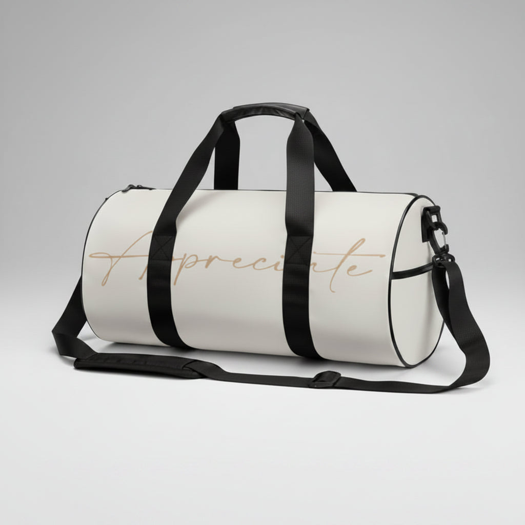 A sleek white gym duffel bag with black straps and a gold cursive appreciate inscription